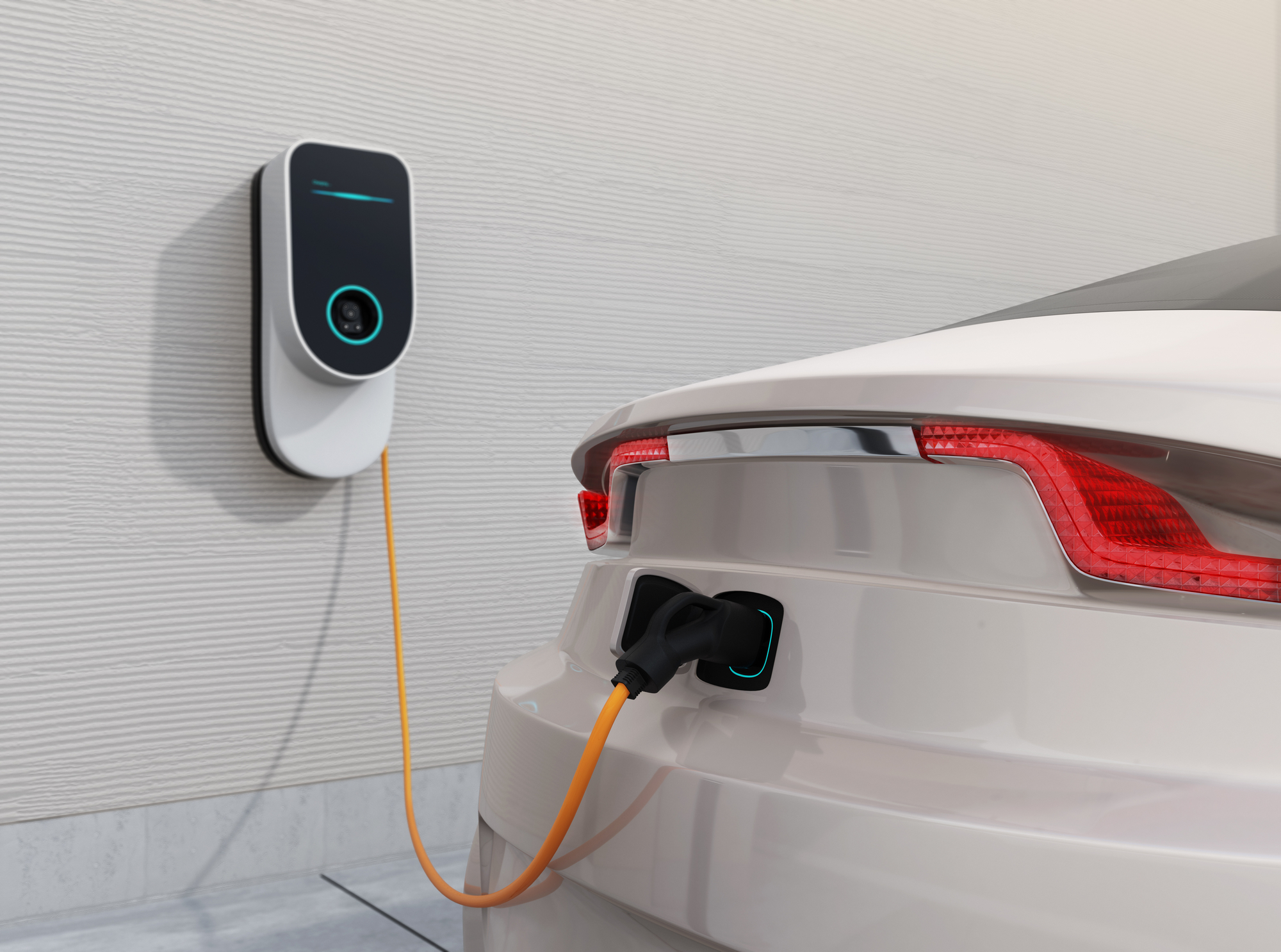 Electric car plugged into a wall-mounted charging station at home