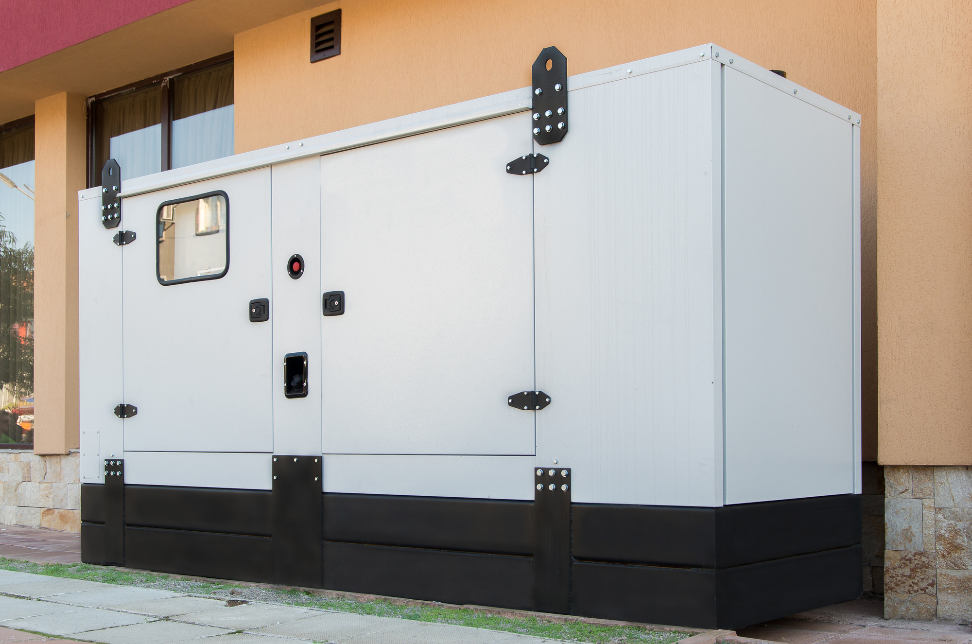 A large, stationary home generator installed outside a residential building